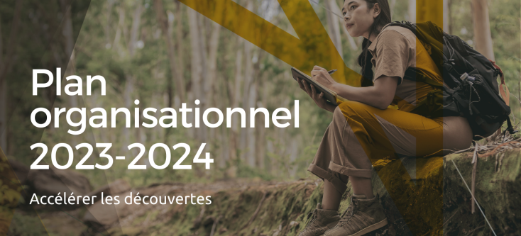 Une image d'une personne assise dans la forêt et prenant des notes accompagnée du texte « Plan organisationnel 2023-24. Accélérer les découvertes ».